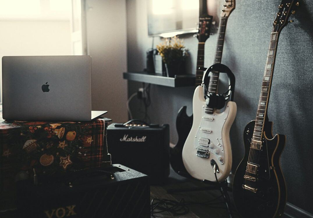 Vintage home recording studio with mixing console and guitars